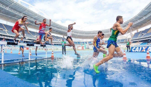 Consulting methods: Runners clearing hurdles in a stadium
