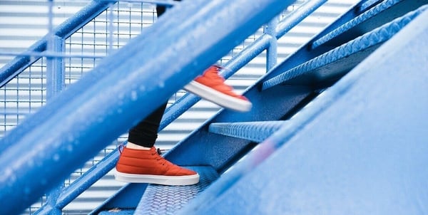 Projektakquise im Consulting: Rote Sneaker auf einer blauen Treppe