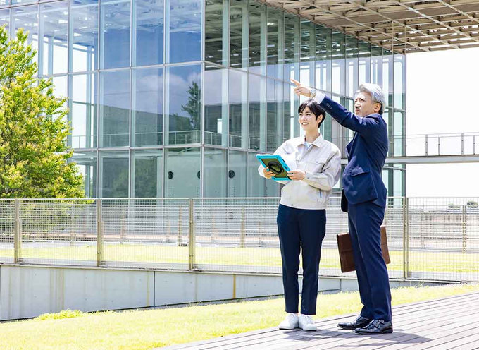 Fachkräfte vor einem Verwaltungsgebäude als Sinnbild für Vergabe- und Sektorenrecht