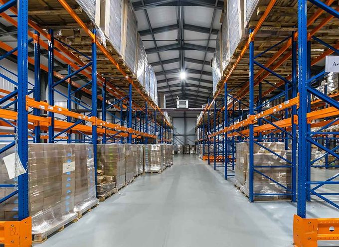 Blick in ein Distributionslager mit Regalreihen und kommissionierten Paletten