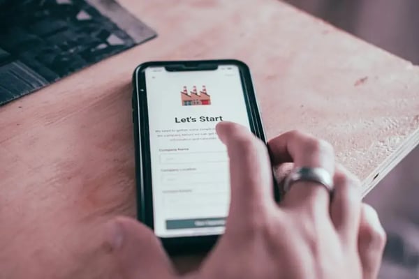 Onboarding new employees: Hands holding a smartphone with a start form