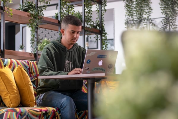 What are freelancers: Young freelancer with a laptop in a café