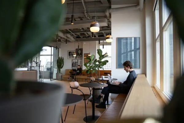 Freelance oder Festanstellung: Person arbeitet allein in einem hellen Café-Büro