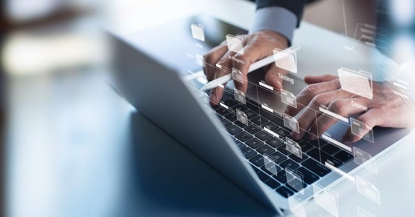 OKR vs. MbO: Hände auf einer Tastatur mit Datenoverlay