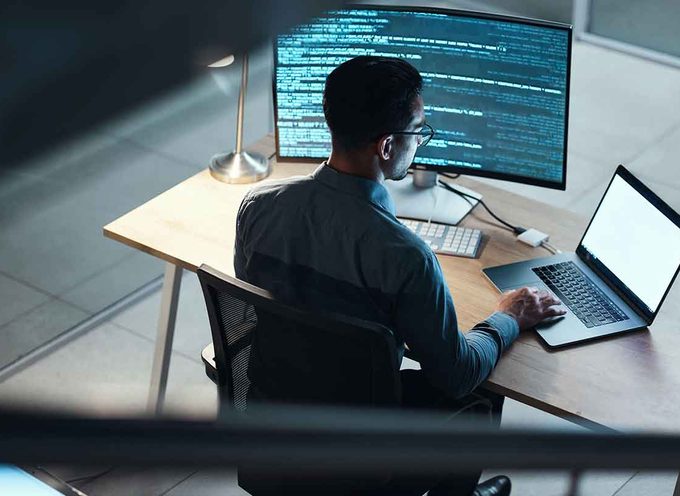Software team at a workstation with several screens