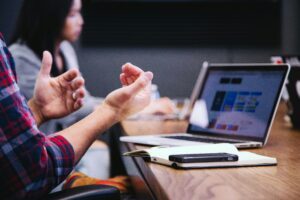 Strategieberatung vs. Managementberatung, Hände, Gestik, beraten, computer im Hintergrund